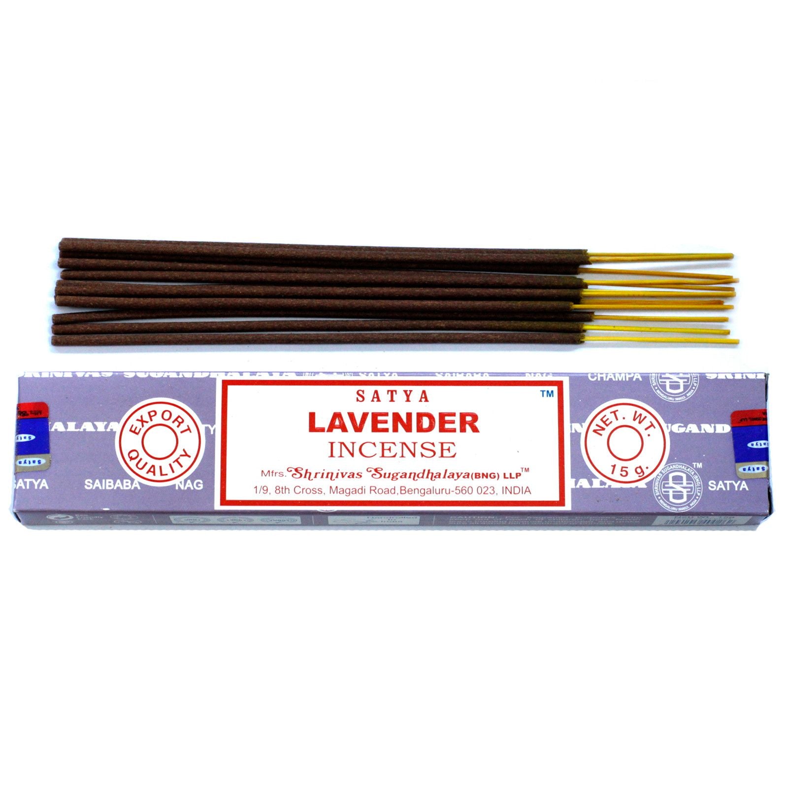 A pack of hand-rolled lavender incense sticks beside a small pile of purple lavender flowers on a neutral surface.