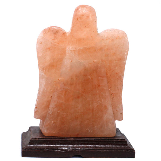 Hand-carved angel shaped Himalayan salt lamp on a wooden base emitting a warm orange glow.