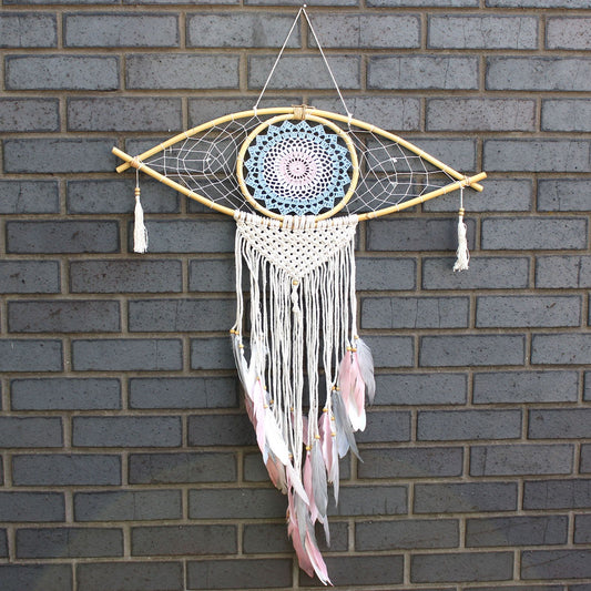 Large blue, white, and pink macrame dream catcher featuring a central woven evil eye design and hanging tassels.