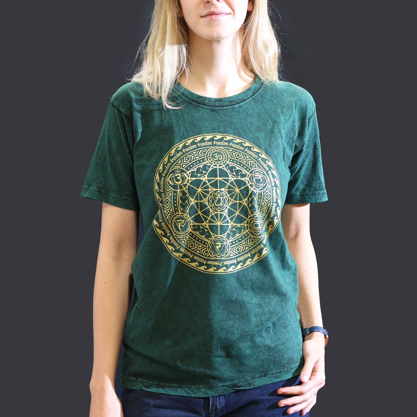 Close up of a green stone washed t-shirt featuring a colourful chakra symbol printed on the front.