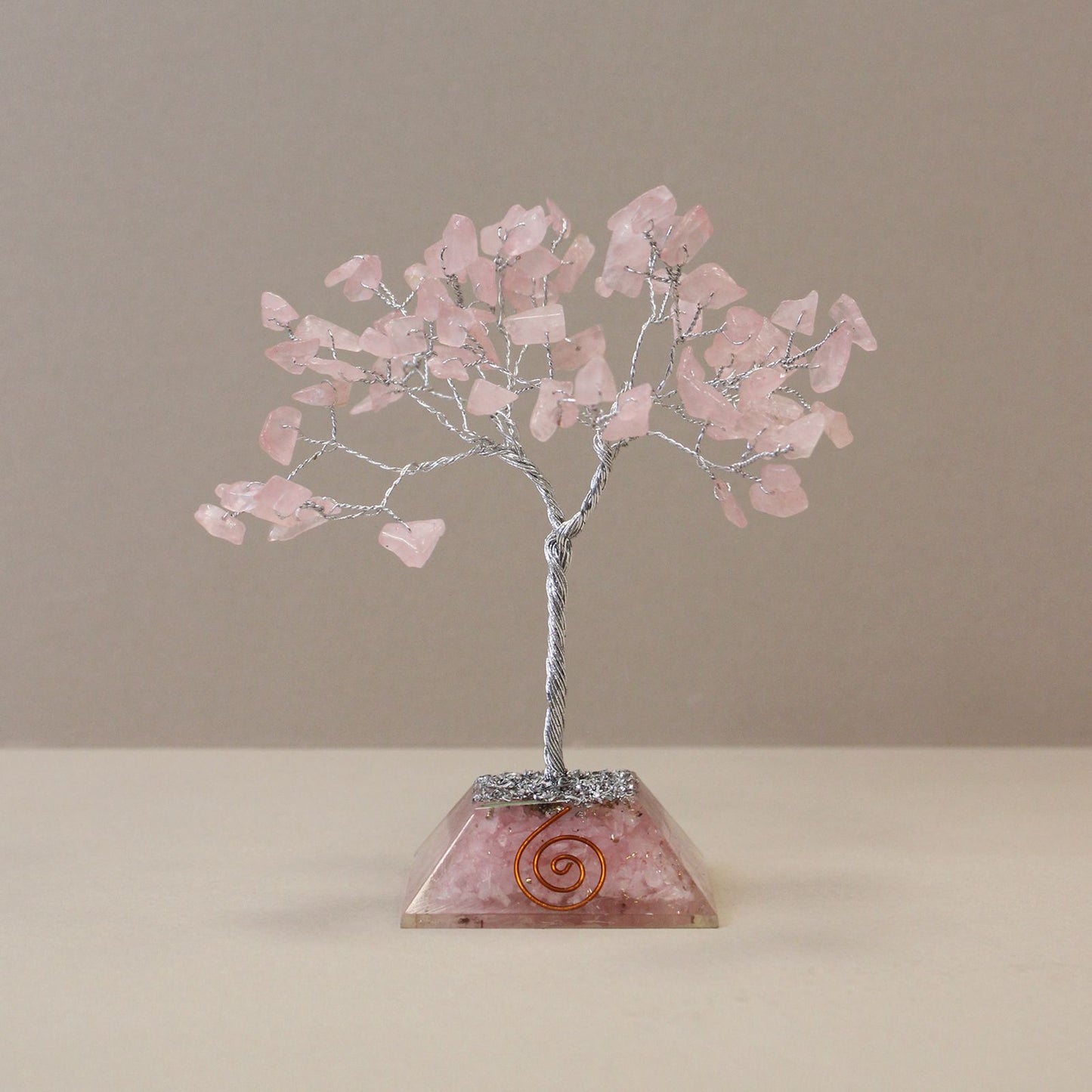 Rose Quartz gemstone tree with eighty pink crystal leaves on a clear resin orgonite base containing golden metal flakes.