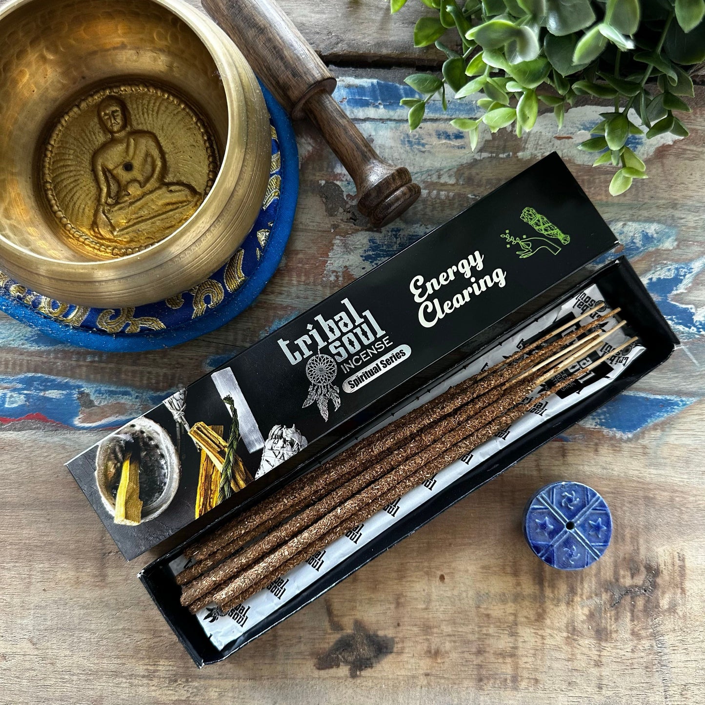 Spiritual incense sticks with a decorative ceramic holder set against a minimalist background for energy clearing.