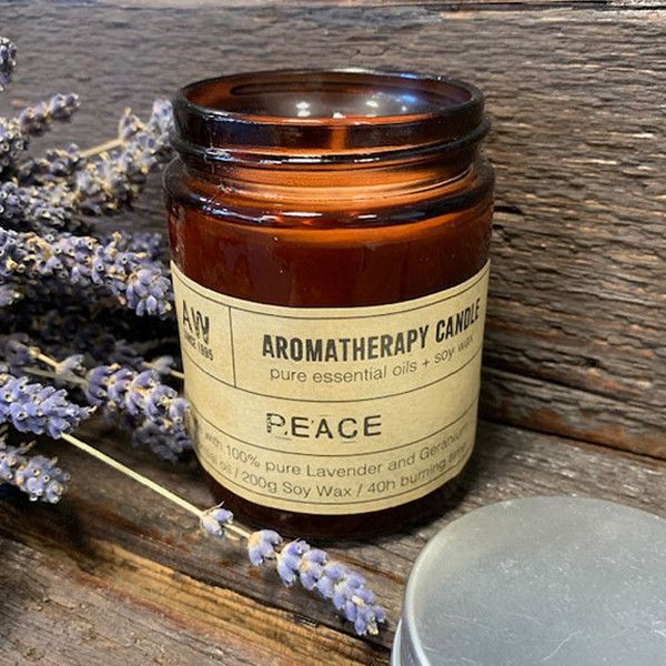 White aromatherapy soy wax candle in a clear glass jar with a minimalist label on a neutral background.