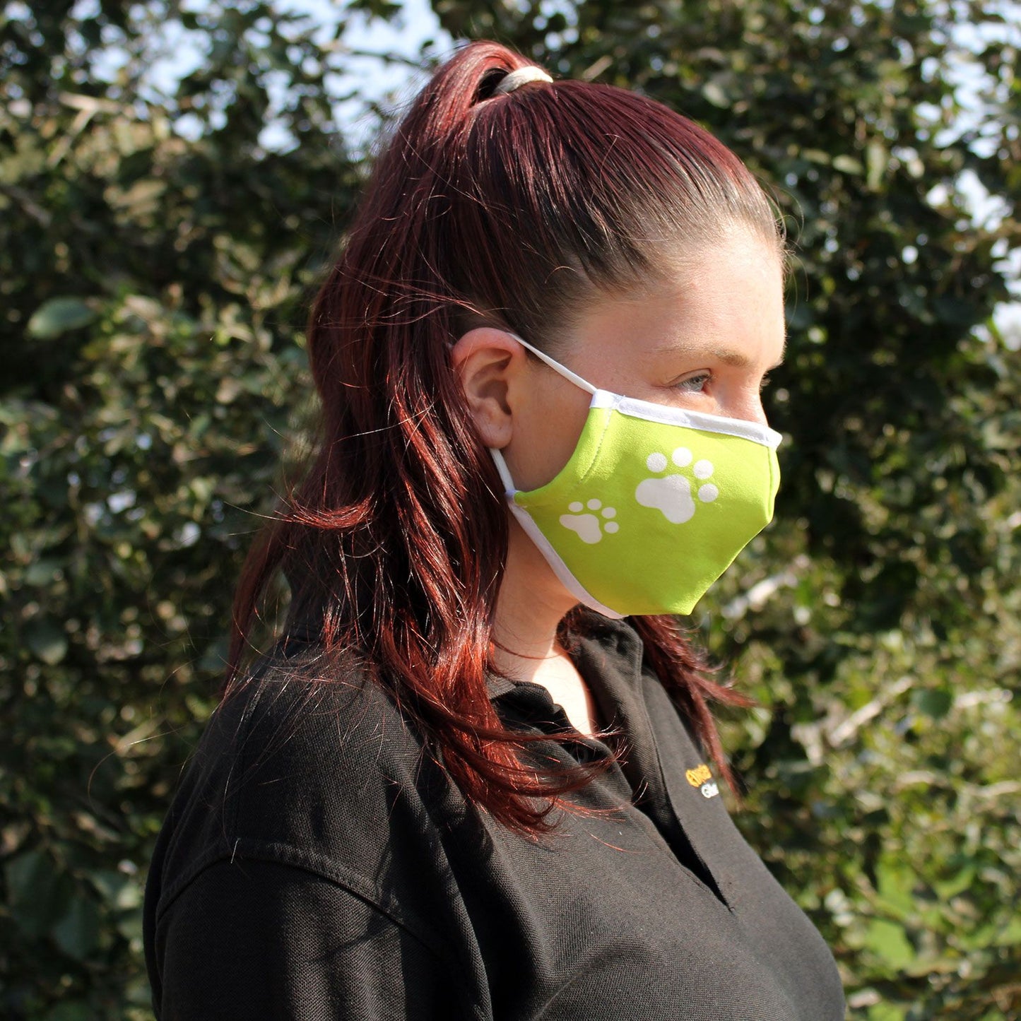 Adult-sized reusable fabric face covering featuring a cute black and white animal paw print pattern.
