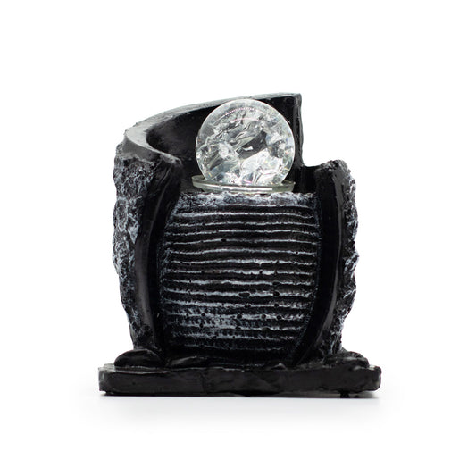 Stone-effect tabletop water feature with a ribbed water pot, crystal ball, and charcoal rock forms.