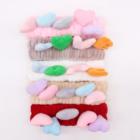 Soft flannel makeup headbands with adorable pink and red love heart designs for beauty routines.