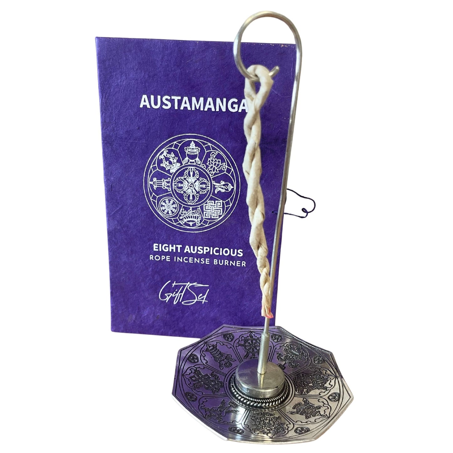 Hand-rolled rope incense bundles alongside a decorative silver-plated holder featuring sacred Astamangal symbols.