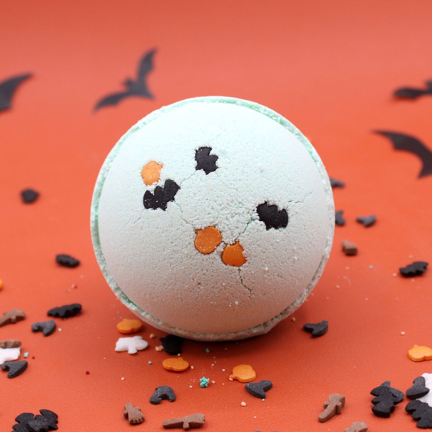 A large round handmade Halloween bath bomb with a textured surface and vibrant colours.