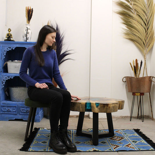 Unique coffee table crafted from durable tamarind wood slabs joined by a vibrant aqua blue resin decorative element.