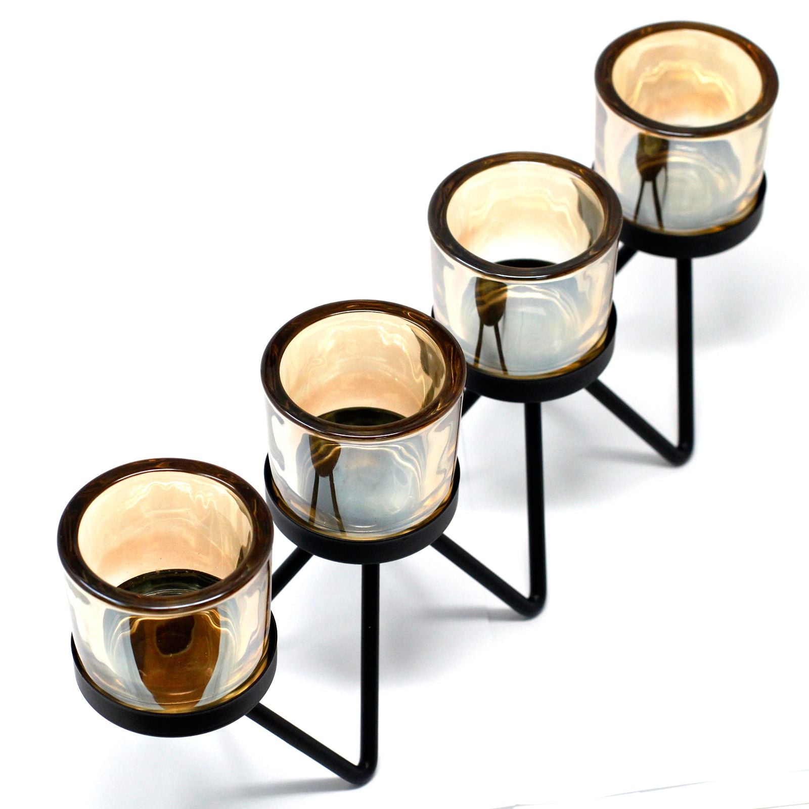 Modern black iron zig-zag candle holder with four glass votive cups on a flat surface.