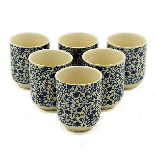 Set of petite handleless ceramic tea cups featuring a delicate blue pattern for mindful herbal tea drinking.