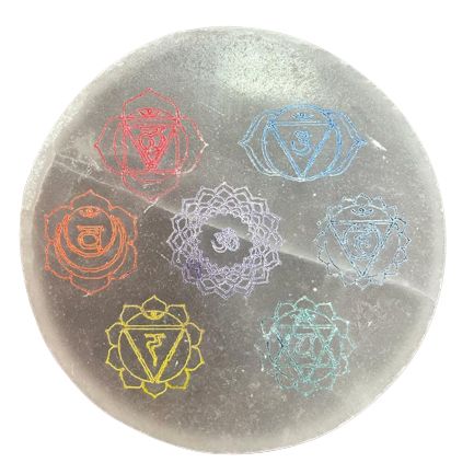 Circular white selenite charging plate featuring a colourful seven chakra symbol design in the centre.
