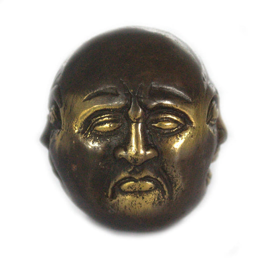 Small polished brass Buddha figurine with four distinct faces representing different emotions on a decorative base.