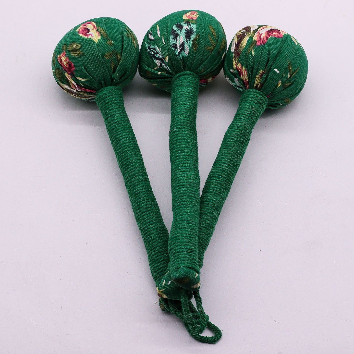 Traditional style green massage hammer made from bamboo and fabric filled with wormwood chips.