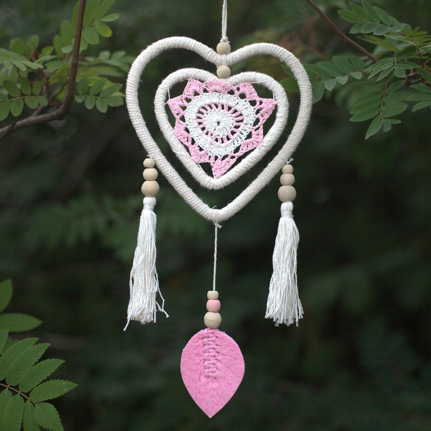 Handmade pink heart-shaped dream catcher with a double heart design and natural woven textures.