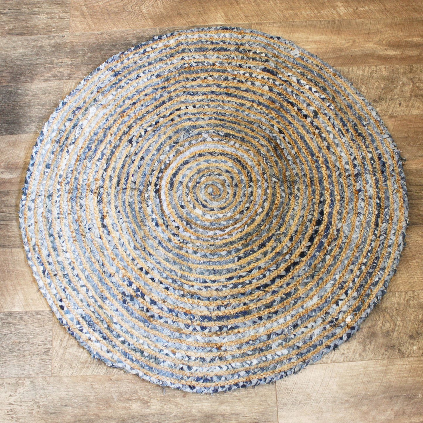 A hand-woven 120cm round rug featuring a textured blend of natural brown jute and blue recycled denim off-cuts.