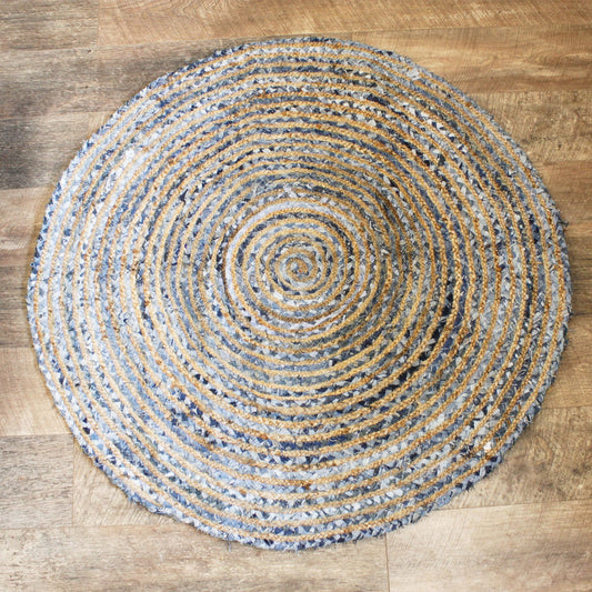 A hand-woven 120cm round rug featuring a textured blend of natural brown jute and blue recycled denim off-cuts.