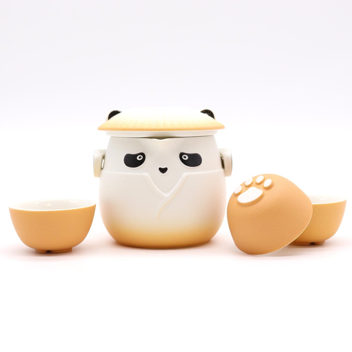 Charming ceramic panda-shaped teapot in vibrant orange with three matching small tea cups.