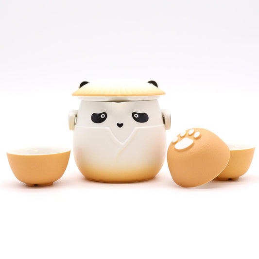 Charming ceramic panda-shaped teapot in vibrant orange with three matching small tea cups.
