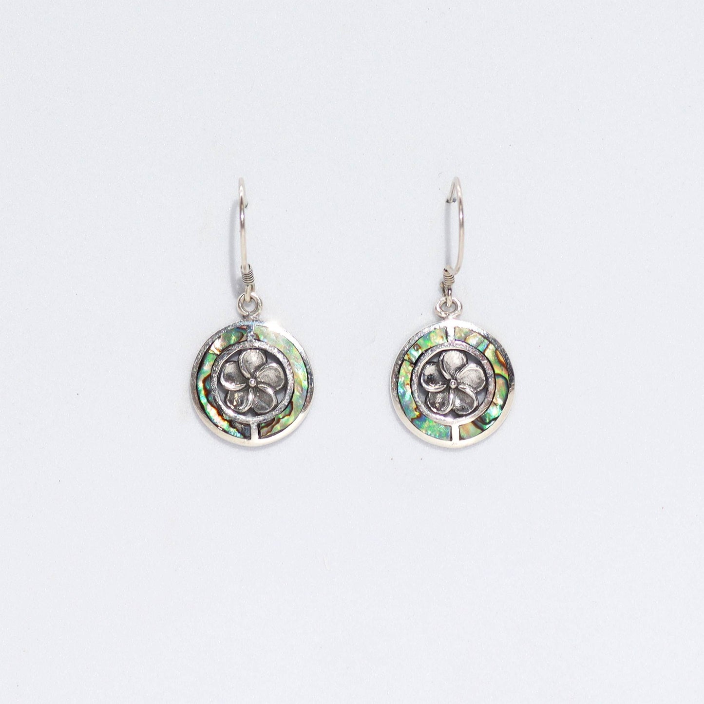 Intricate frangipani flower earrings crafted from iridescent abalone shell and sterling silver.