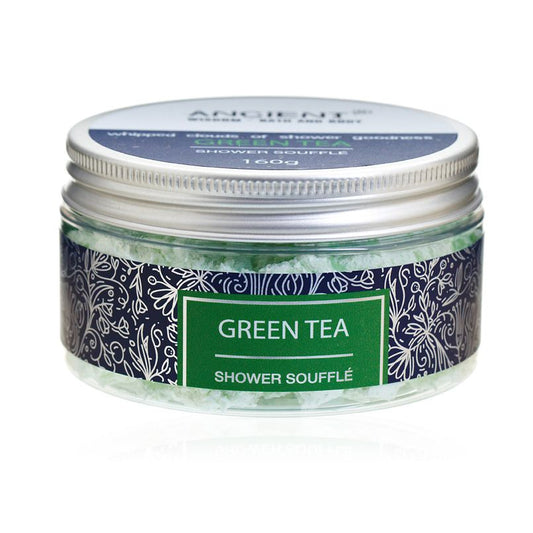 Light and fluffy green tea scented shower soufflé foam in a clear tub, showing its creamy and airy consistency.