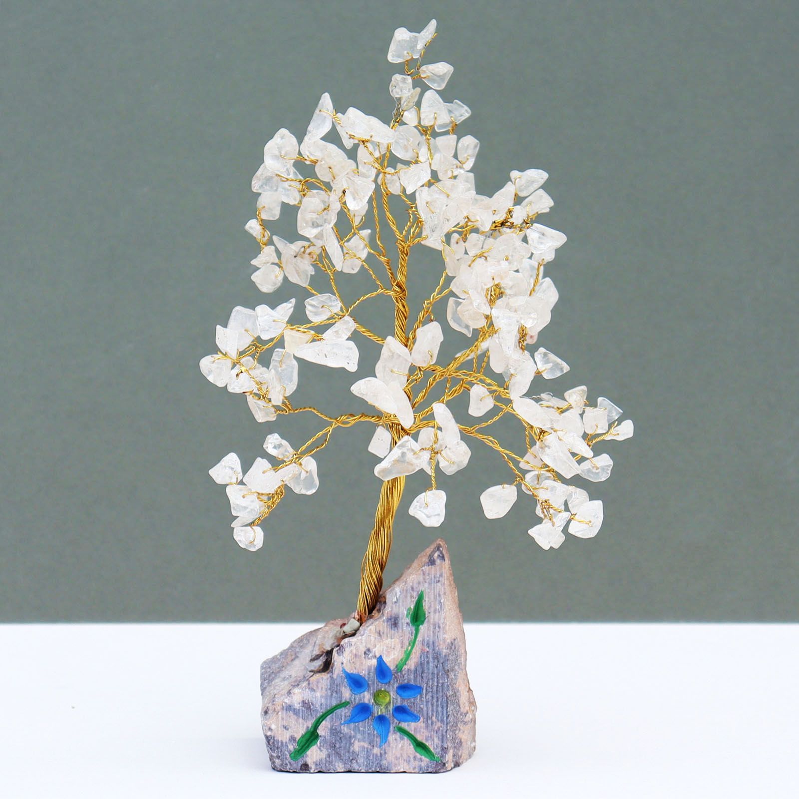 Handcrafted gemstone tree featuring clear rock crystal quartz leaves on adjustable wire branches with a natural stone base.