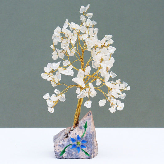 Handcrafted gemstone tree featuring clear rock crystal quartz leaves on adjustable wire branches with a natural stone base.