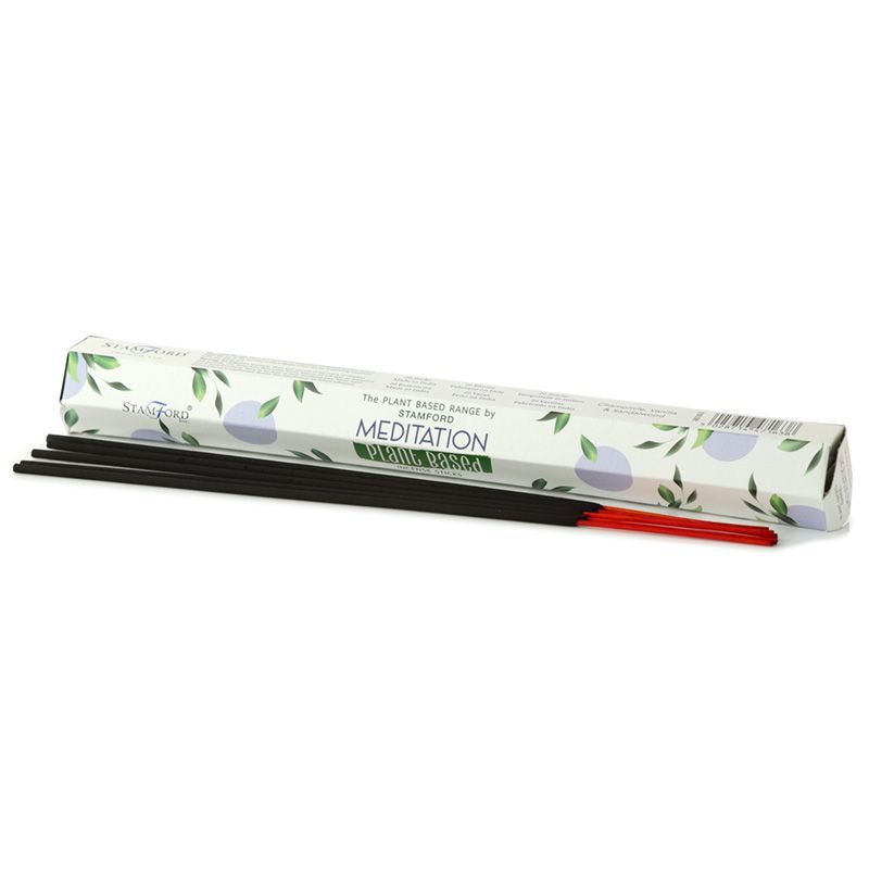 A bundle of natural plant-based meditation incense sticks resting on a wooden surface with a soft focus background.
