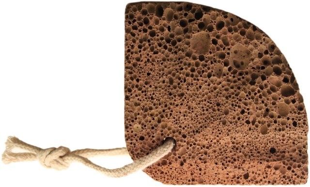 Natural porous grey volcanic lava foot stone carved into a decorative shell shape for skin exfoliation.