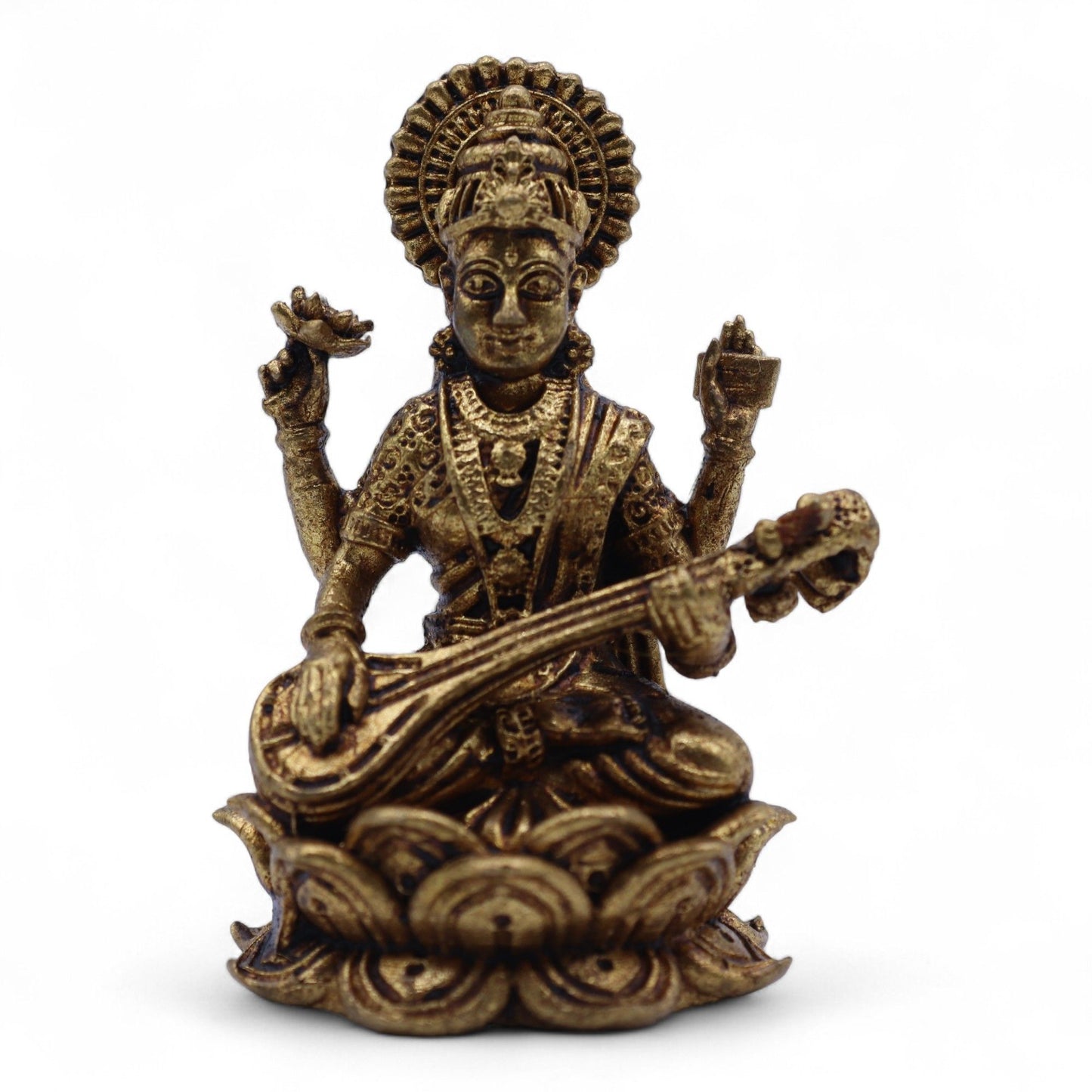Handcrafted brass miniature of Goddess Saraswati seated on a lotus pedestal holding a veena with detailed carvings.