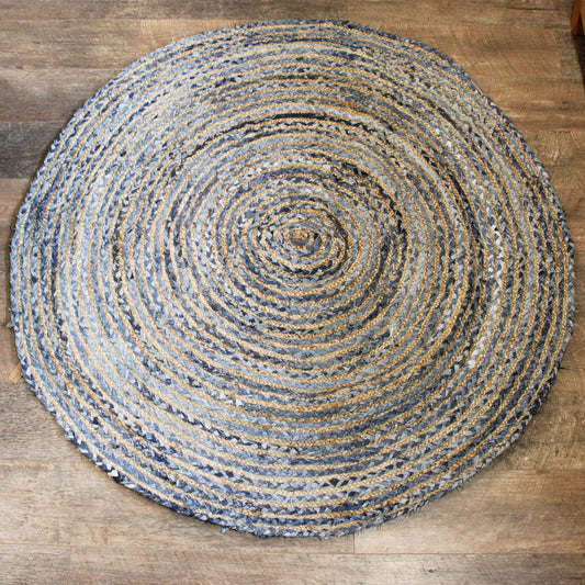 Large round hand-woven rug made from natural jute and blue recycled denim off-cuts in a spiral pattern.