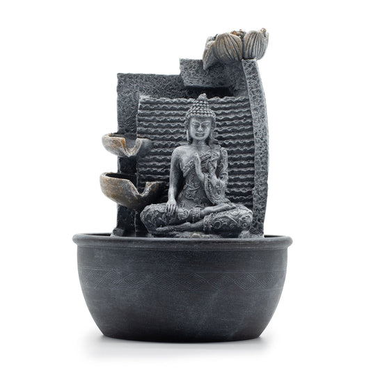Tabletop indoor fountain featuring a seated Buddha figure with water cascading through lotus-shaped bowls.