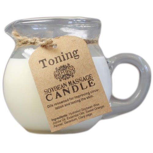 Toning and firming soy wax massage candle in a ceramic pouring jar with essential oil botanicals.