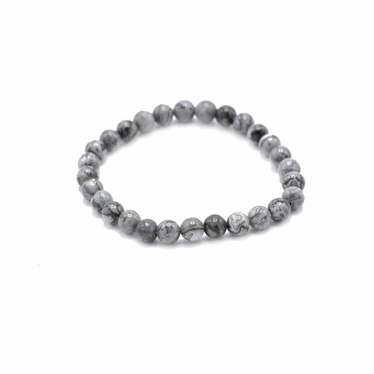 Close-up of a beaded gemstone bracelet featuring grey and black marbled Map Stone beads on an elastic cord.