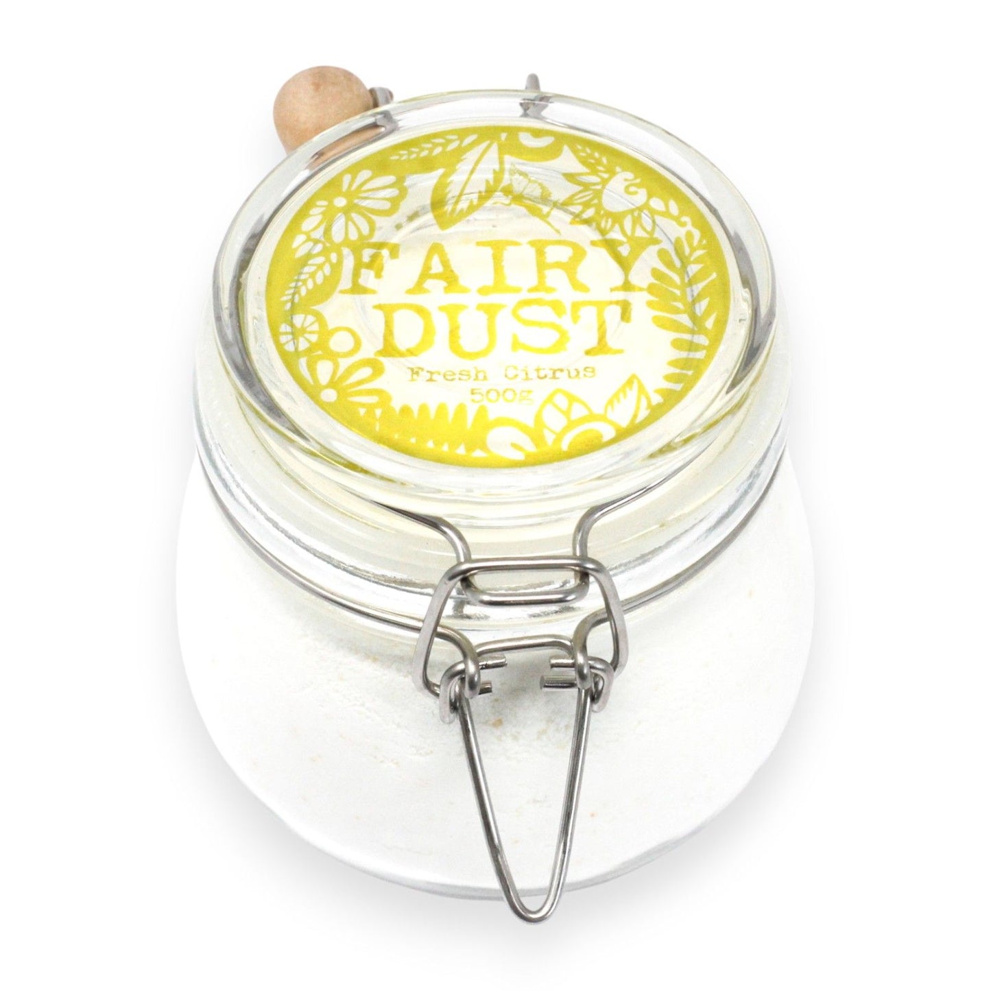 Fine zesty orange and yellow bath dust in a glass jar with a wooden scoop on a white surface.