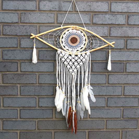 Handcrafted medium macrame dream catcher with a central Evil Eye design in white, grey, and brown woven threads.