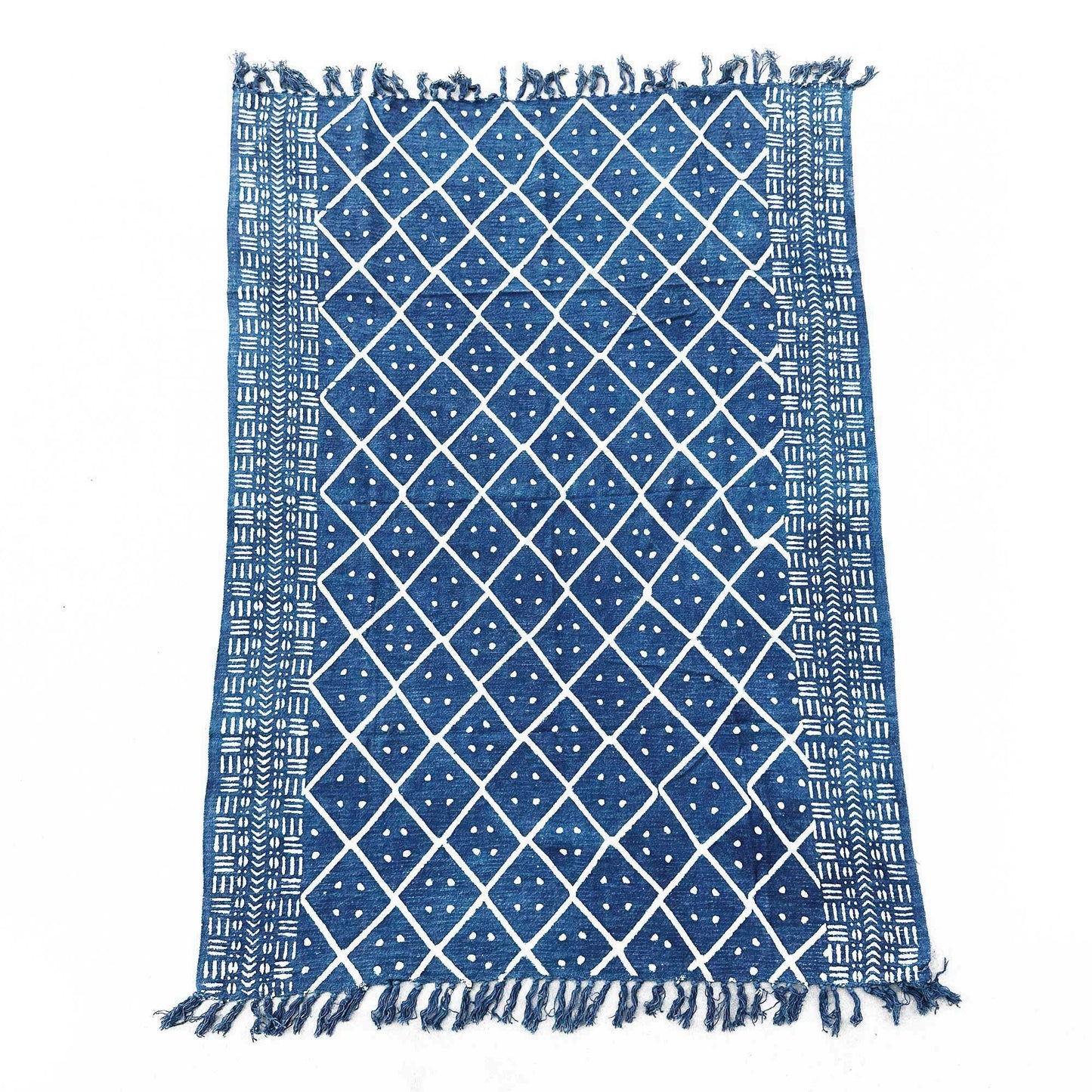 Close-up of a handmade indigo throw featuring an intricate white Midnight Heerak geometric pattern with fringed edges.