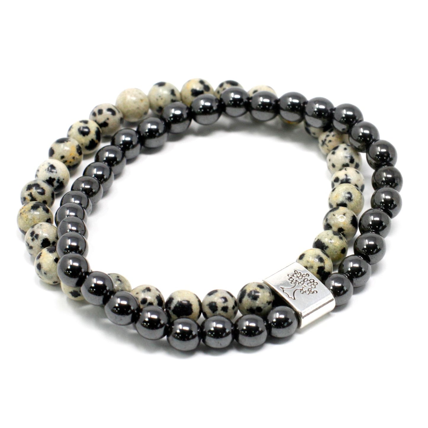 Close-up of a magnetic gemstone bracelet featuring speckled black and beige Dalmation Jasper beads on a stretch cord.