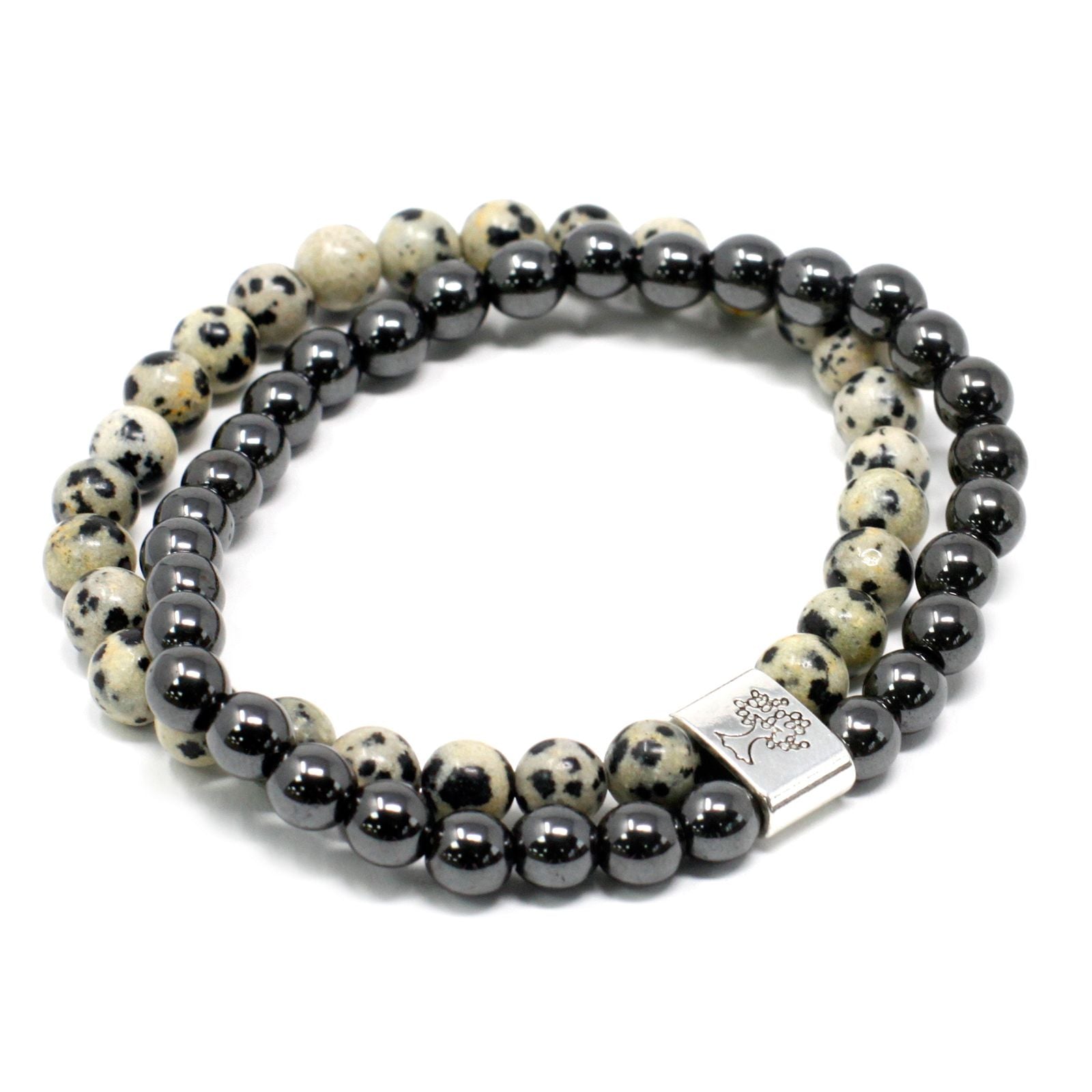 Close-up of a magnetic gemstone bracelet featuring speckled black and beige Dalmation Jasper beads on a stretch cord.