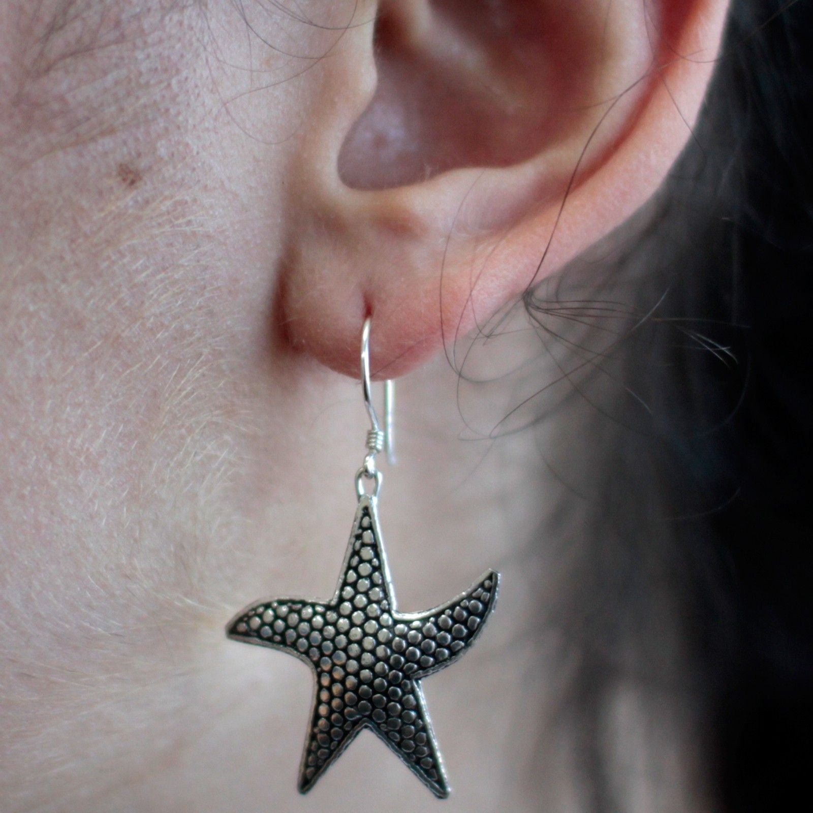 Delicately detailed 925 sterling silver starfish drop earrings with a polished finish.
