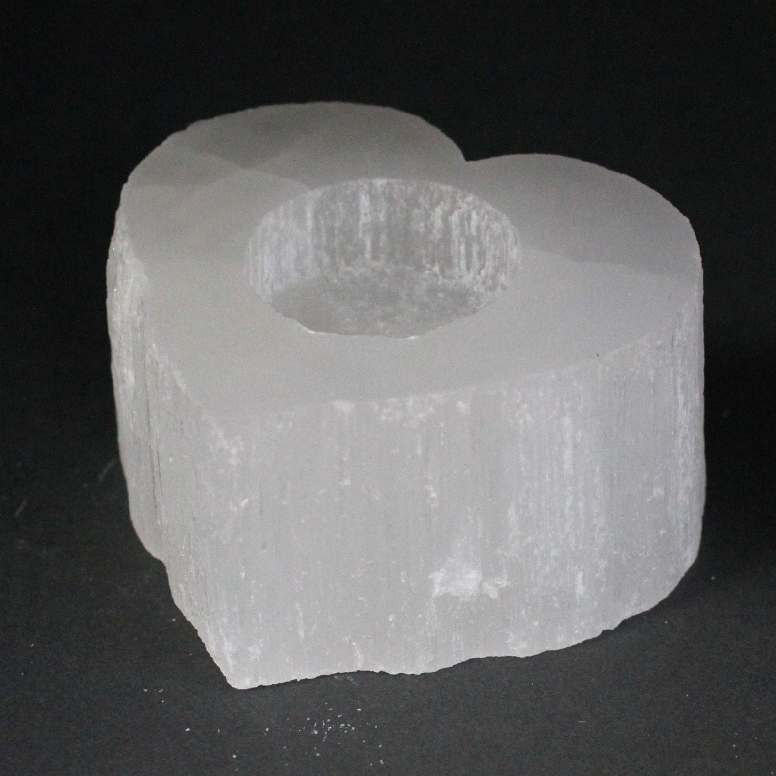 Heart-shaped selenite candle holder with a natural rough edge and a translucent white crystal finish.