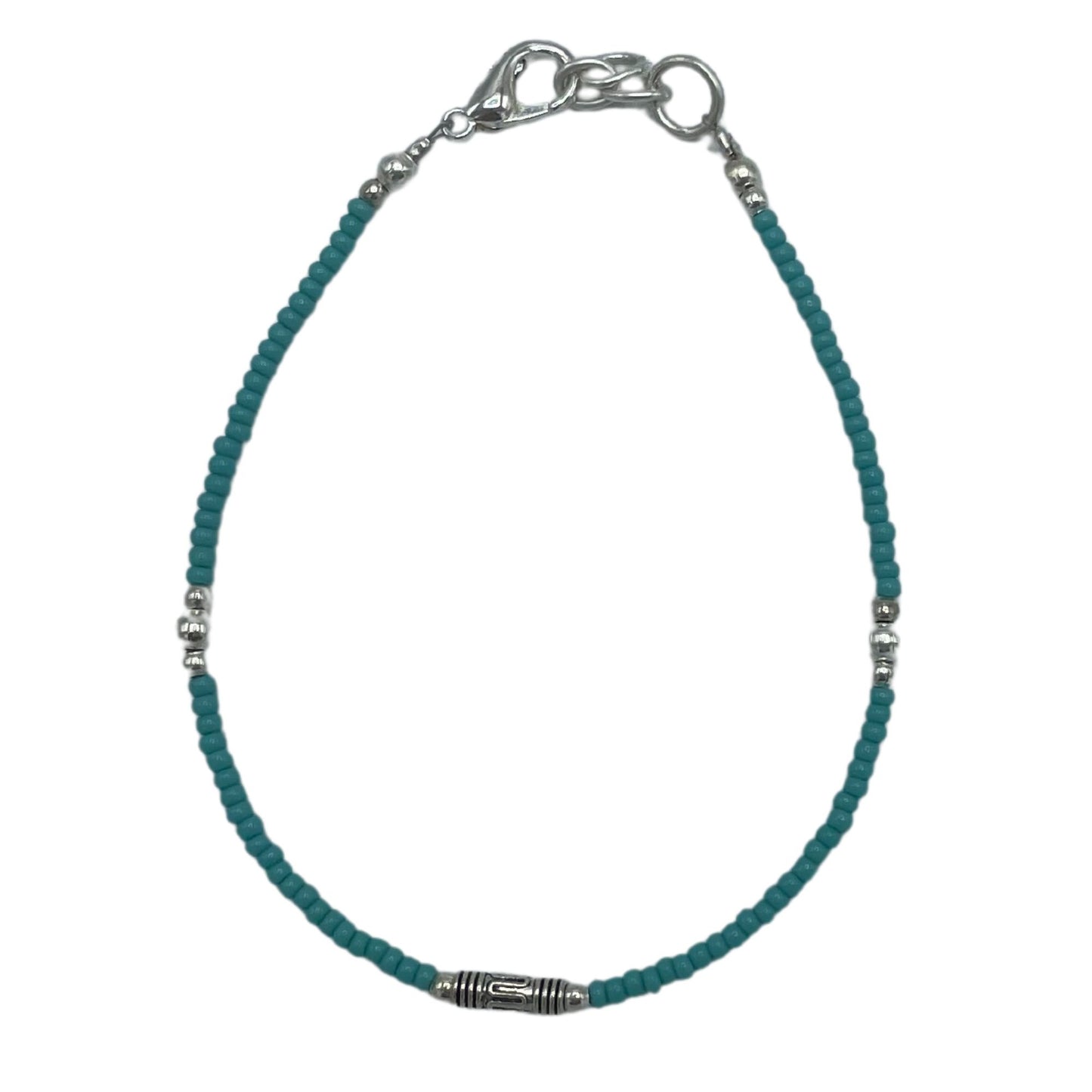 Delicate silver bracelet featuring vibrant blue turquoise stones and ornate teardrop-shaped metal accents.