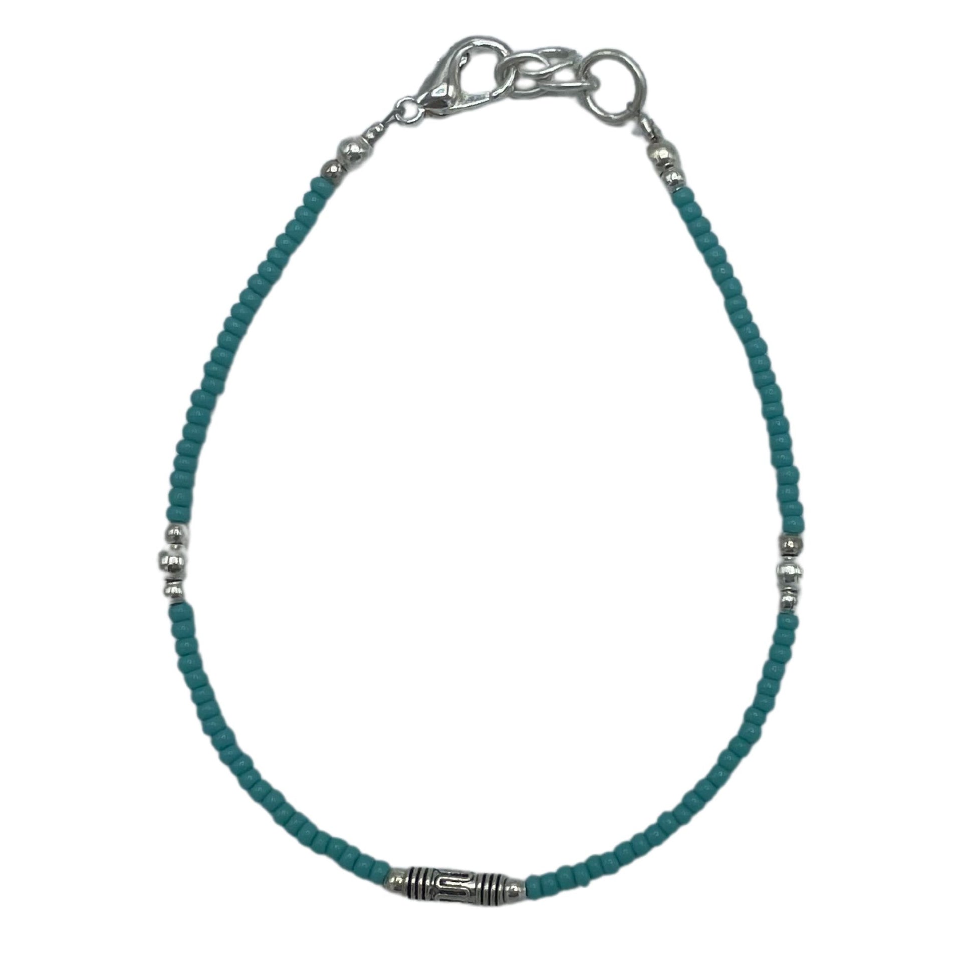 Delicate silver bracelet featuring vibrant blue turquoise stones and ornate teardrop-shaped metal accents.