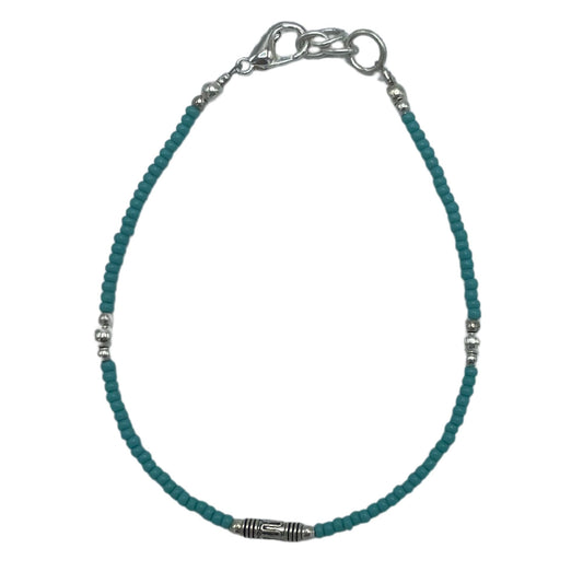 Delicate silver bracelet featuring vibrant blue turquoise stones and ornate teardrop-shaped metal accents.
