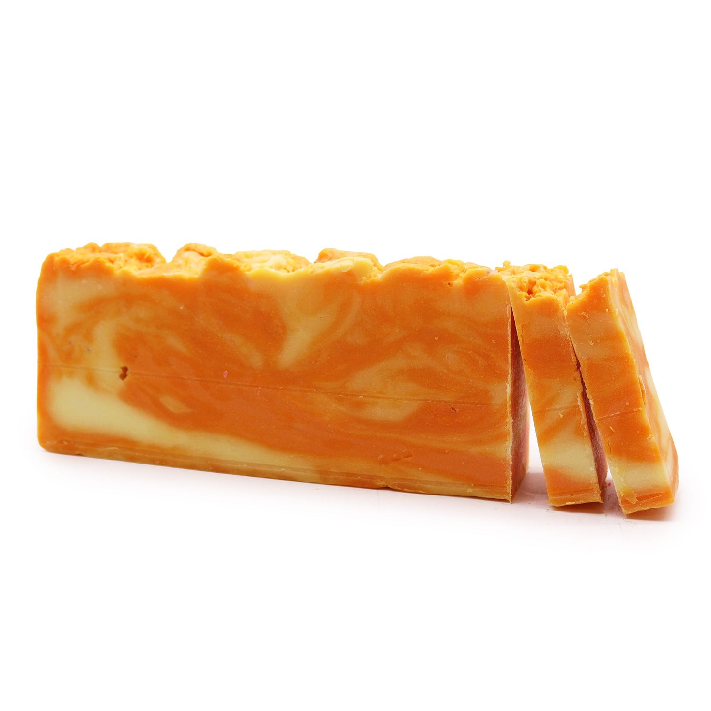 A large textured rectangular loaf of handmade orange-scented olive oil soap with a natural, rustic appearance.