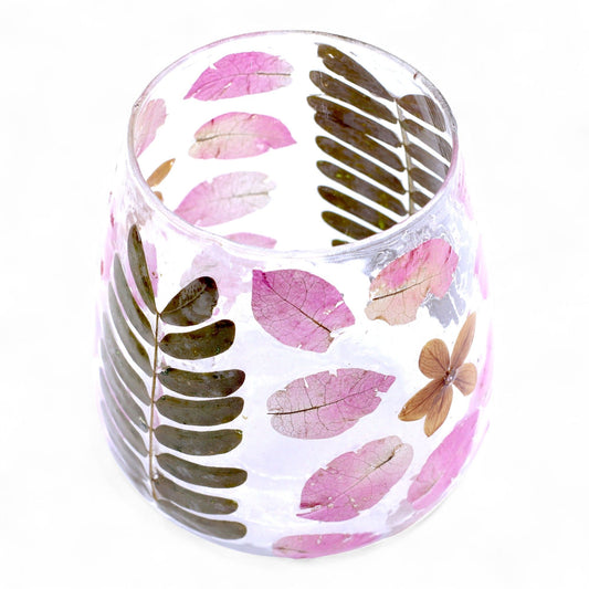 Handcrafted clear glass vase candle holder containing delicate real dried flowers for a natural aesthetic.