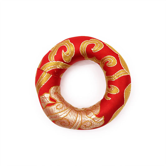 Small red fabric hoop cushion designed to support a singing bowl on a flat surface.
