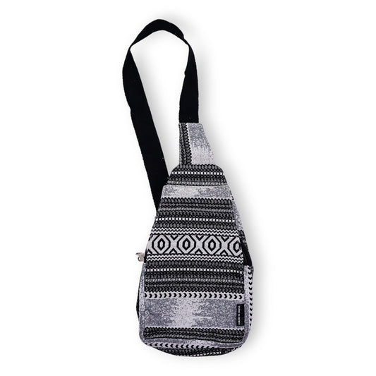 Handmade jacquard crossbody bag with a bold black and white geometric monochrome pattern and a long shoulder strap.