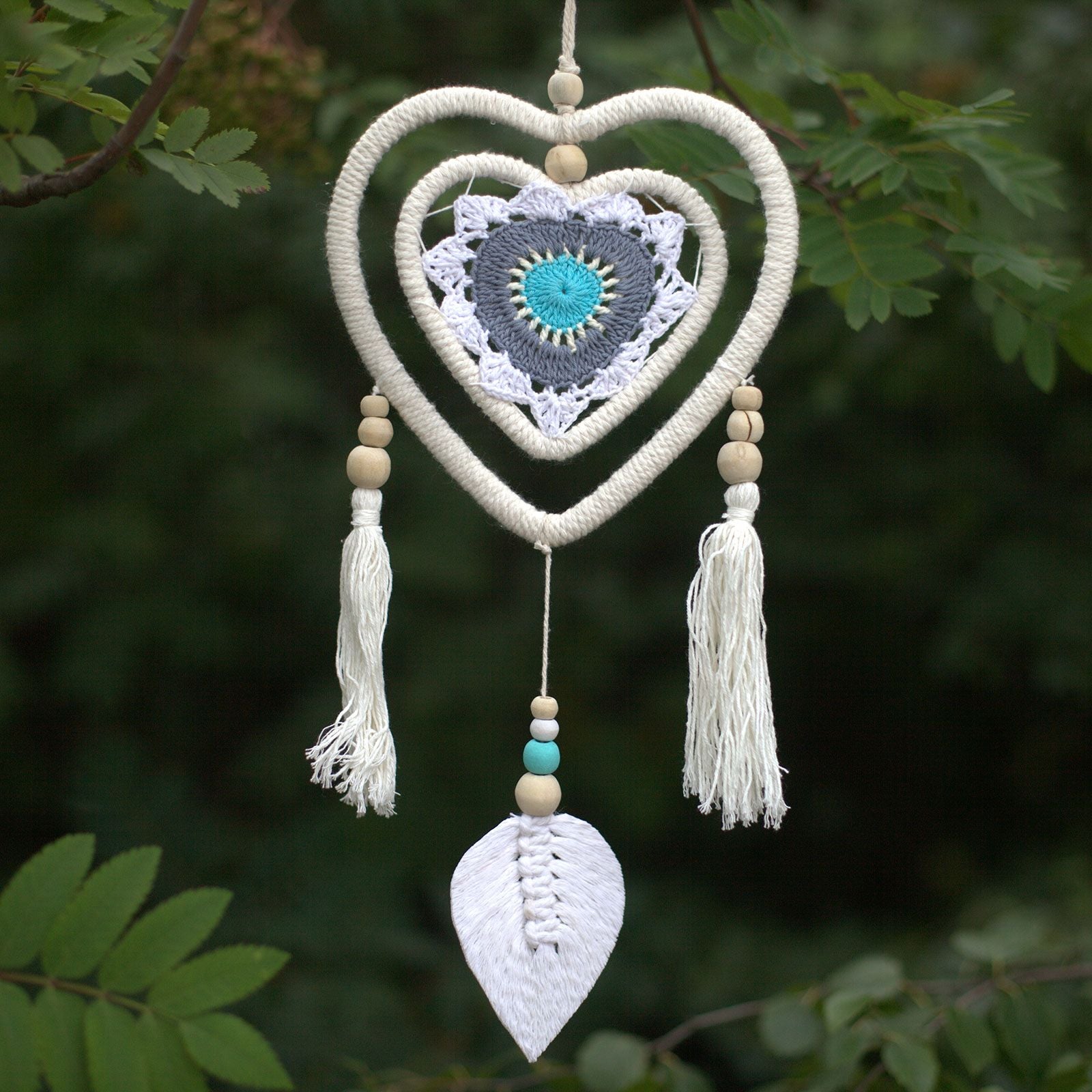 Blue heart-shaped dream catcher with an intricate woven web and hanging blue beads, handmade without feathers.
