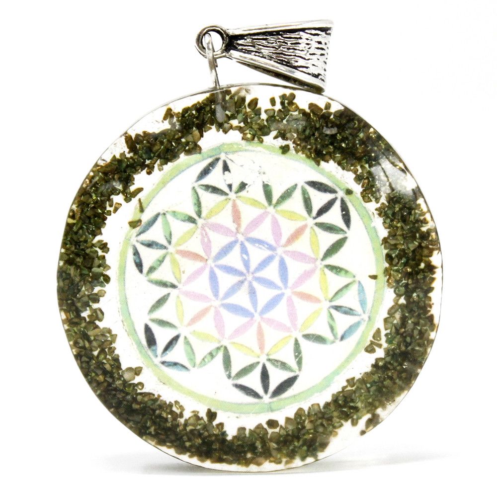 Circular orgonite pendant featuring green gemstone chips, copper metal filings, and an esoteric mandala symbol.